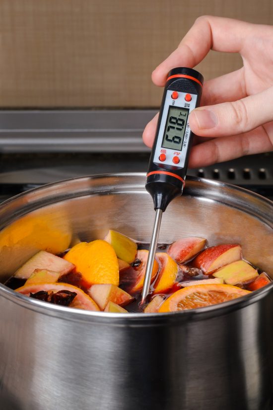 the process of making mulled wine in a saucepan